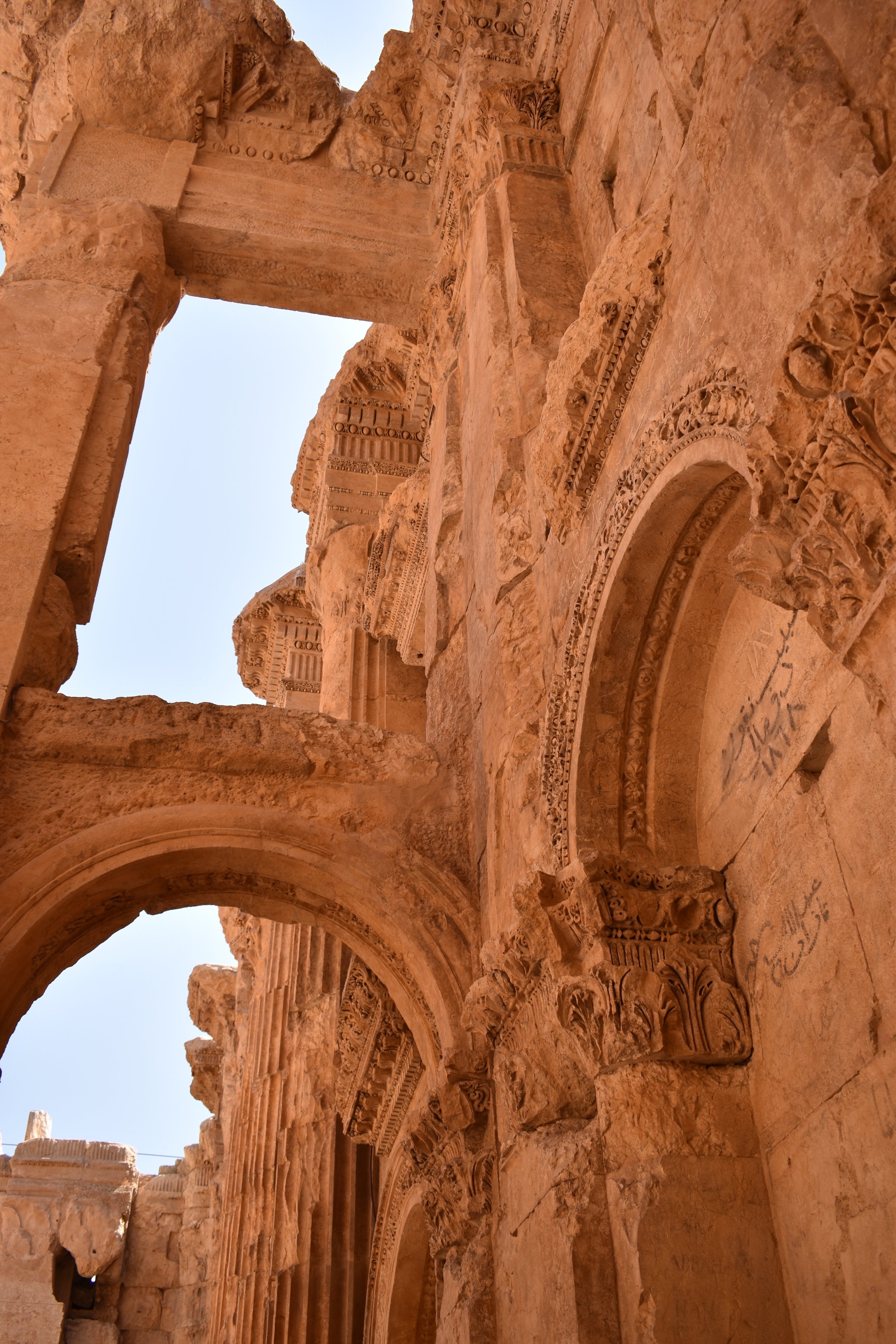 Close-up view of ancient stone ruins with detailed carvings and arches, part of a historic archaeological site.