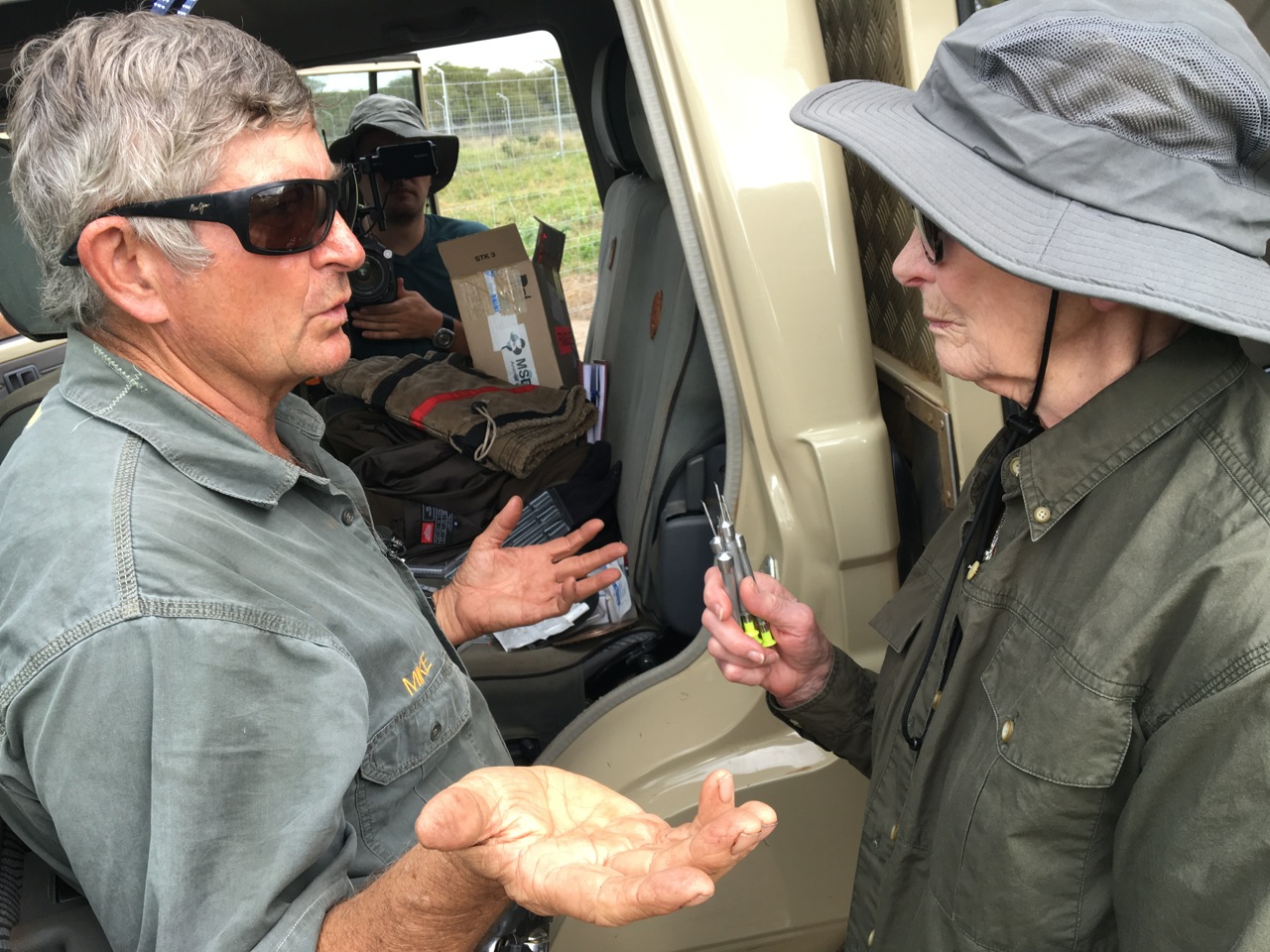 Dr. Mike Toft preparing darts and explaining the drugs to Mary Cabela.