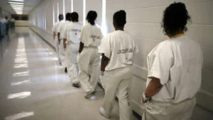 Women walk along a corridor at the Los Angeles County women’s jail in Lynwood, California April 26, 2013. The Second Chance Women’s Re-entry Court is one of the first in the U.S. to focus on women, and offers a cost-saving alternative to prison for women who plead guilty to non-violent crimes and volunteer for treatment. Of the 297 women who have been through the court since 2007, 100 have graduated, and only 35 have been returned to state prison. REUTERS/Lucy Nicholson (UNITED STATES – Tags: CRIME LAW) – GM2E94R0Q8D01