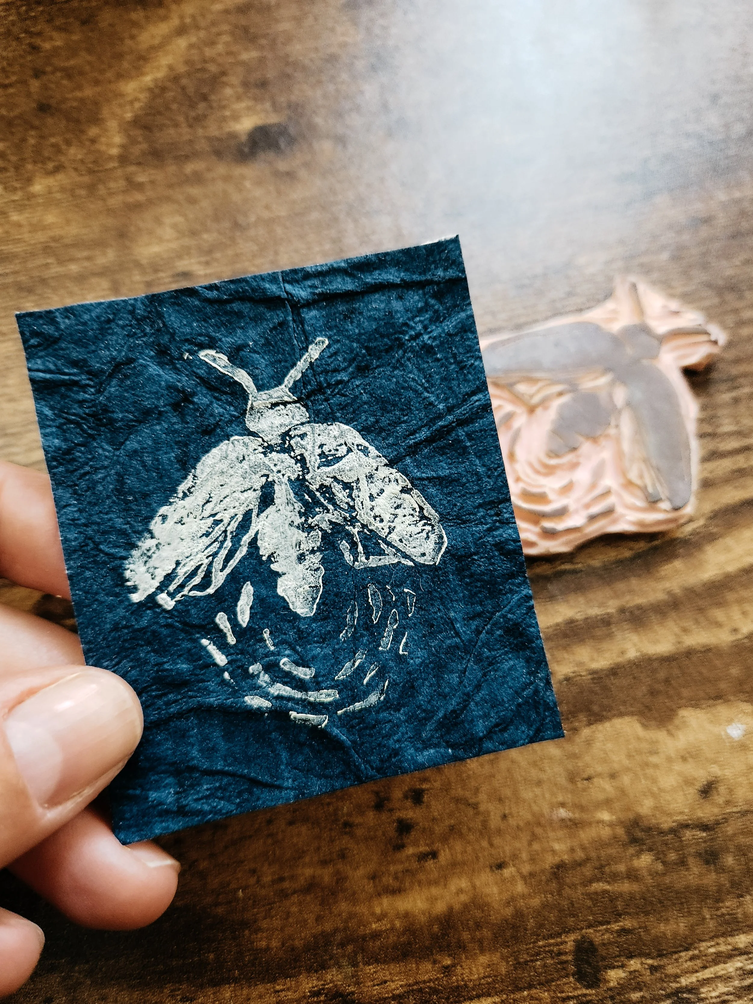 Handmade firefly lino print shown with the carved lino stamp used to create the design.