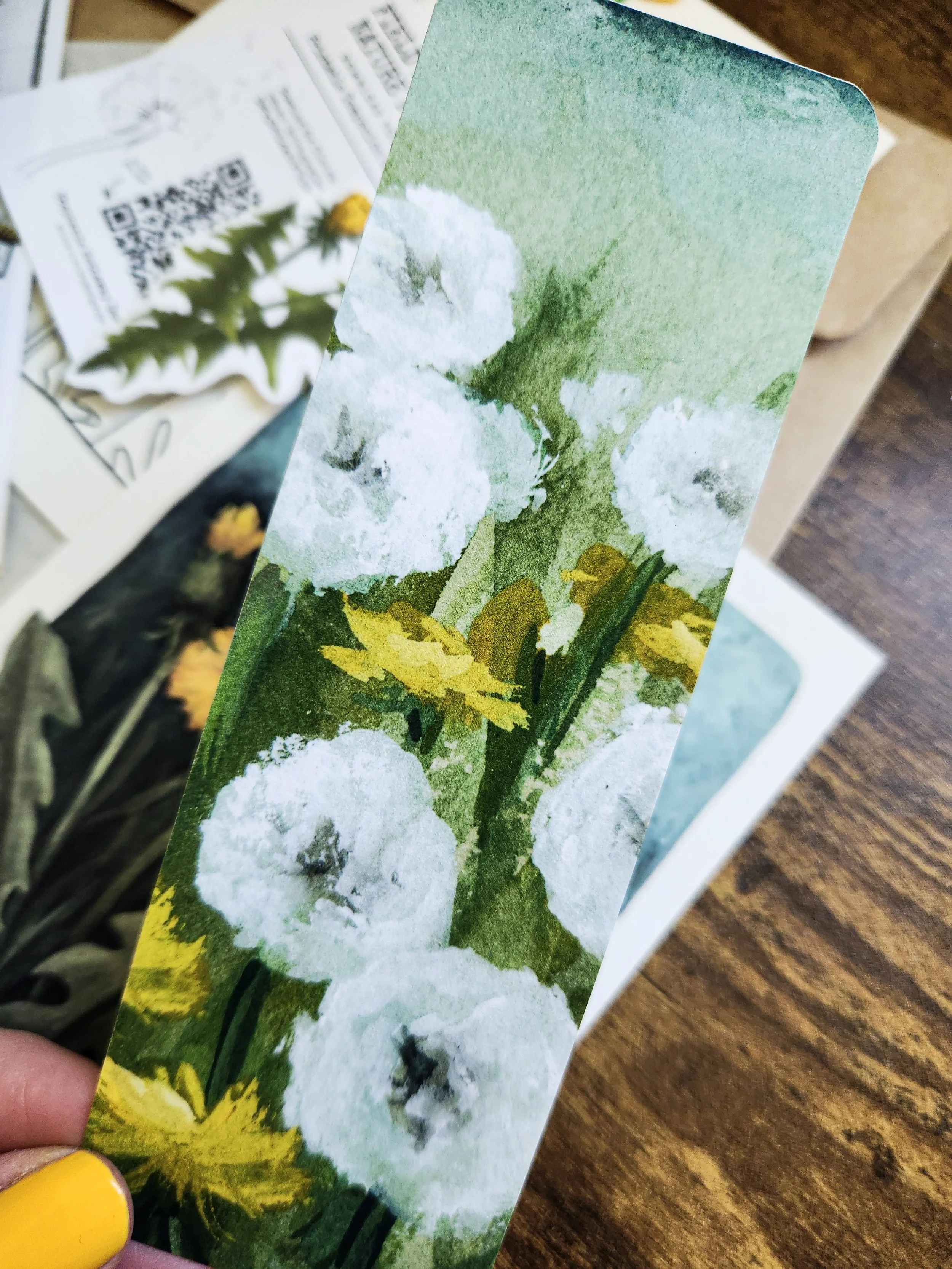 Bookmark featuring dandelion artwork printed on textured paper.