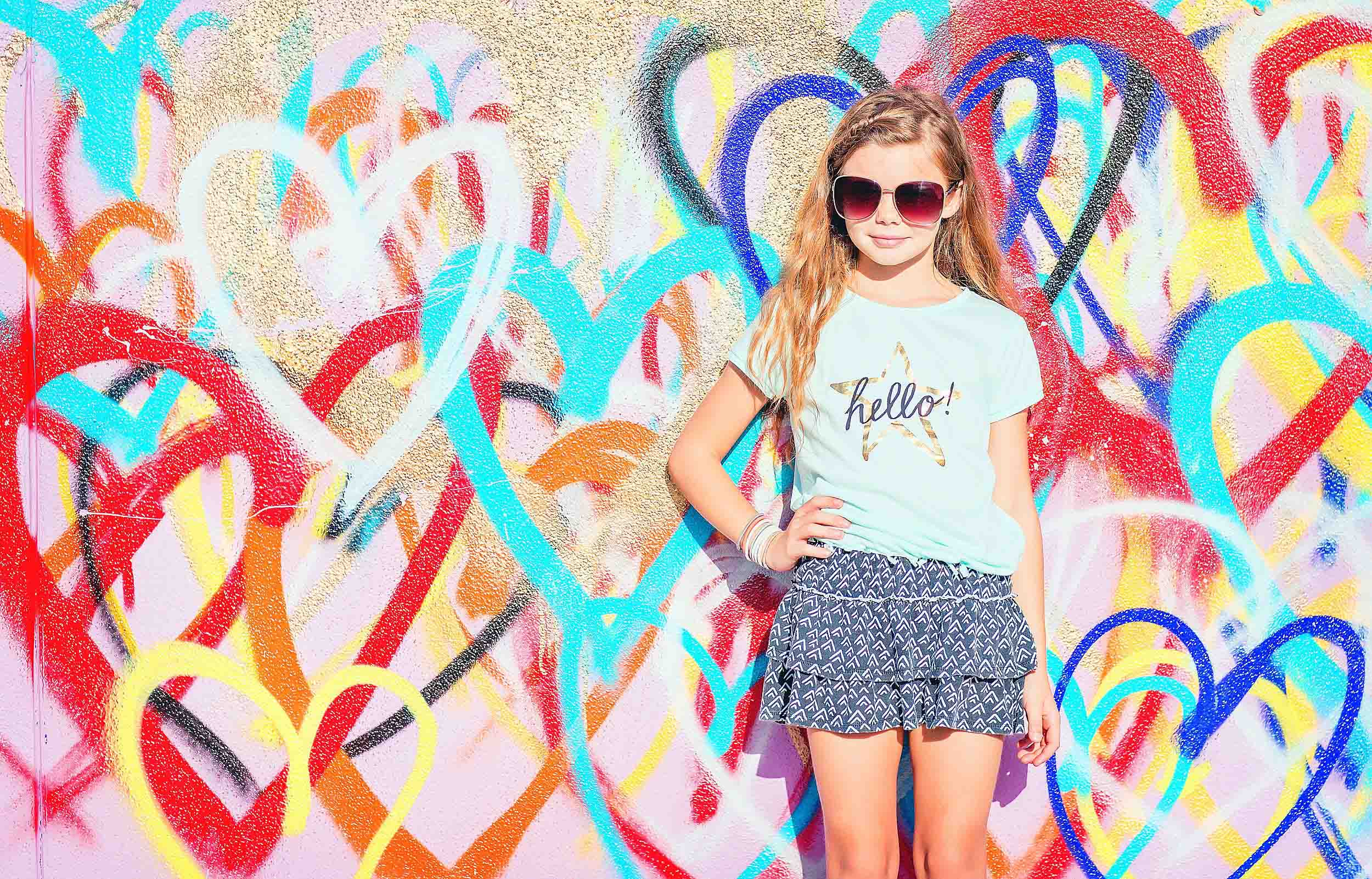 Colorful portrait of young girl against wall art in Houston, Texas. 