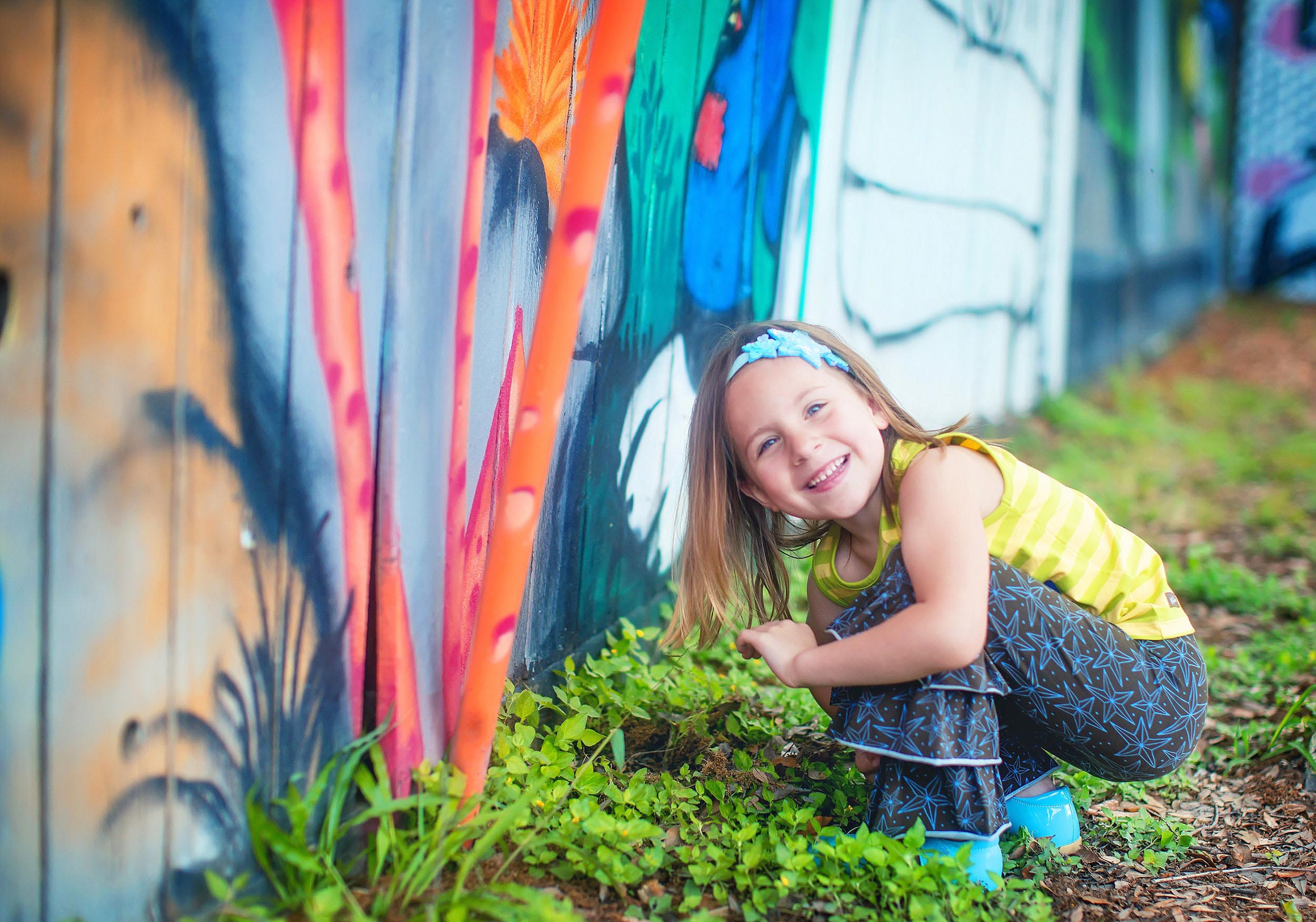  Colorful lifestyle portrait of little girl by art walls in Houston by spryART photography. 