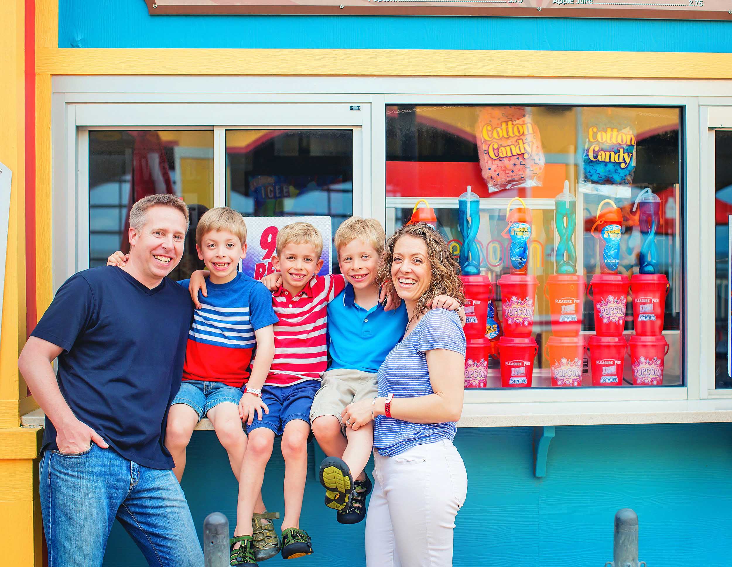  Family portrait of mom and dad and triplets on Pleasure Pier in Galveston, Texas by spryART photography. 