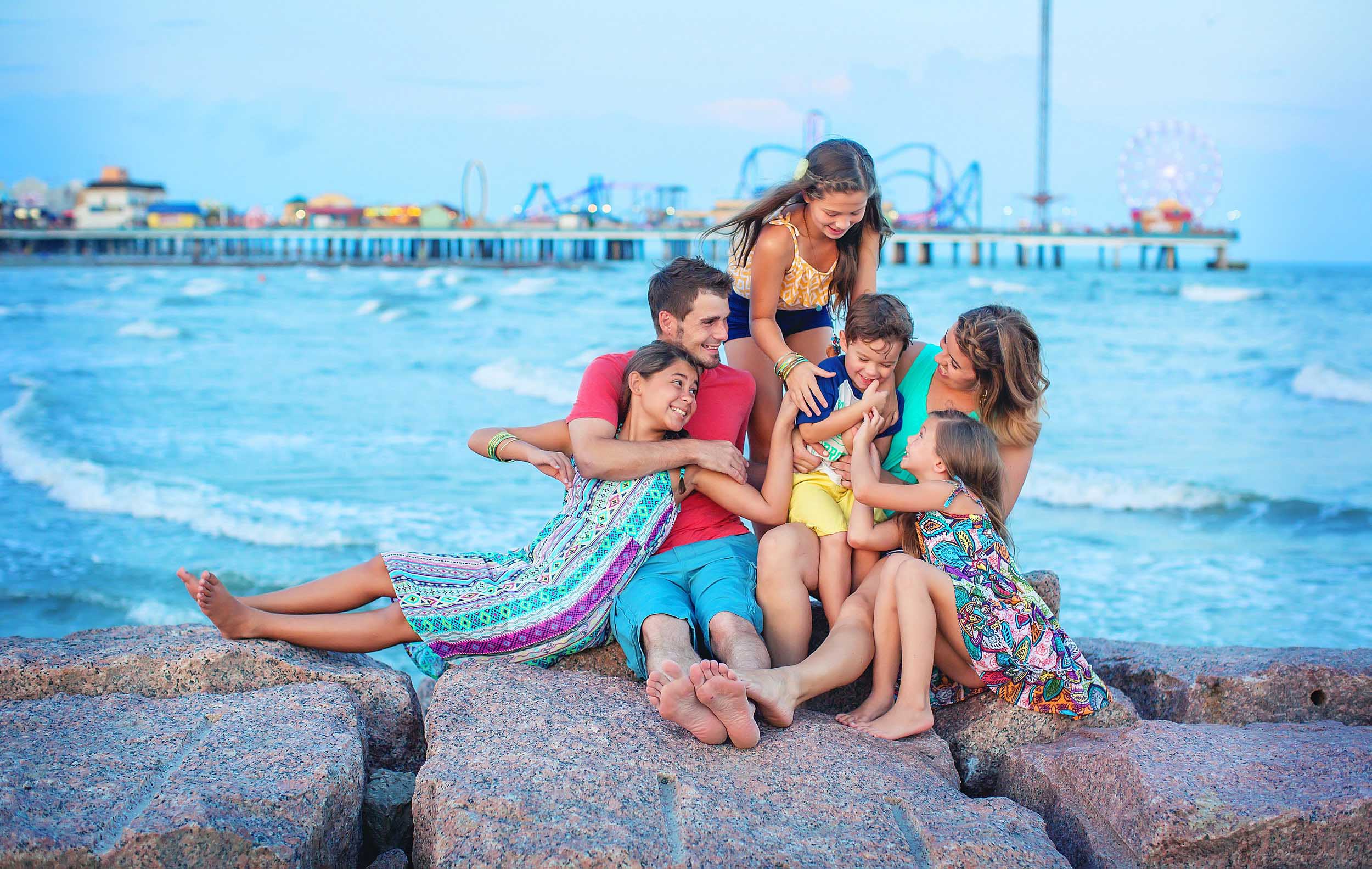  Lifestyle family picture in Galveston, Texas with Pleasure Pier in the background by spryART photography. 