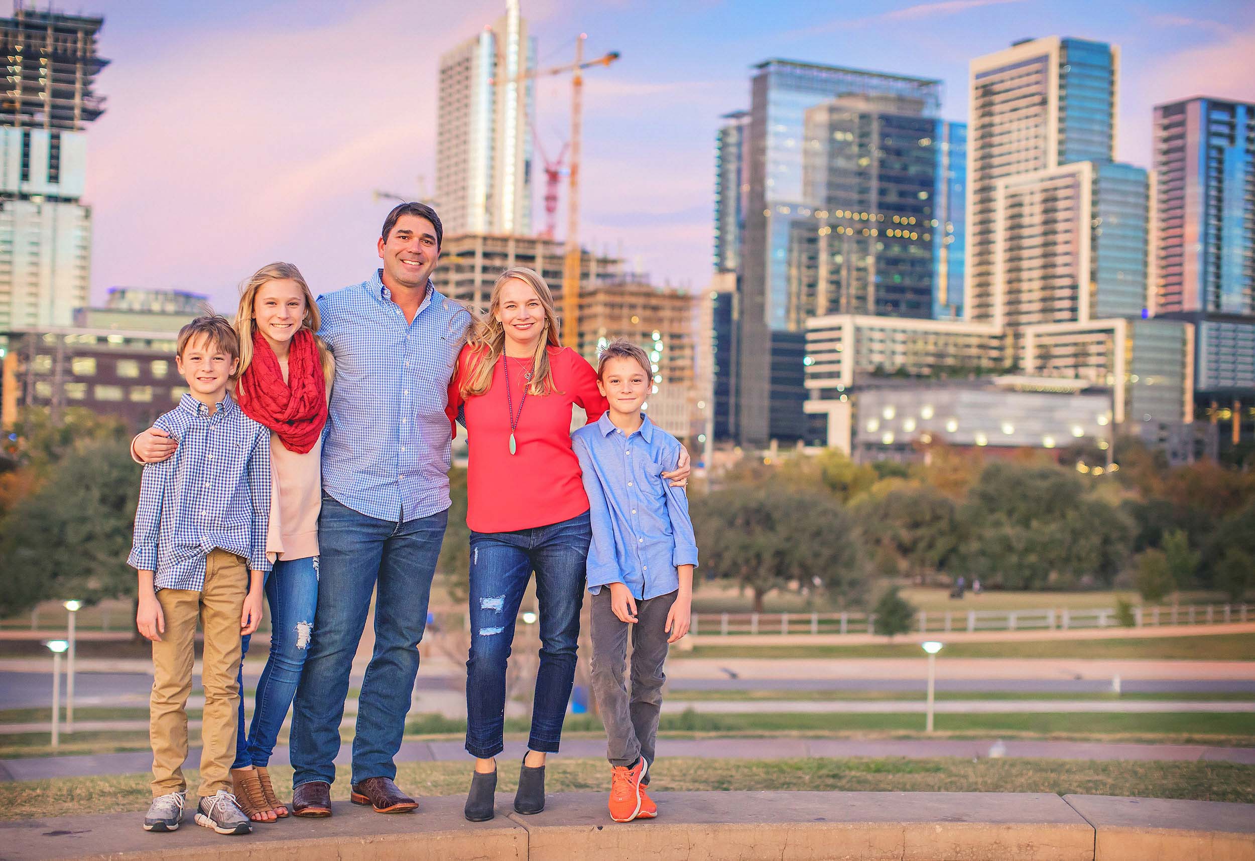  Family portrait at dusk with skyline behind them. 