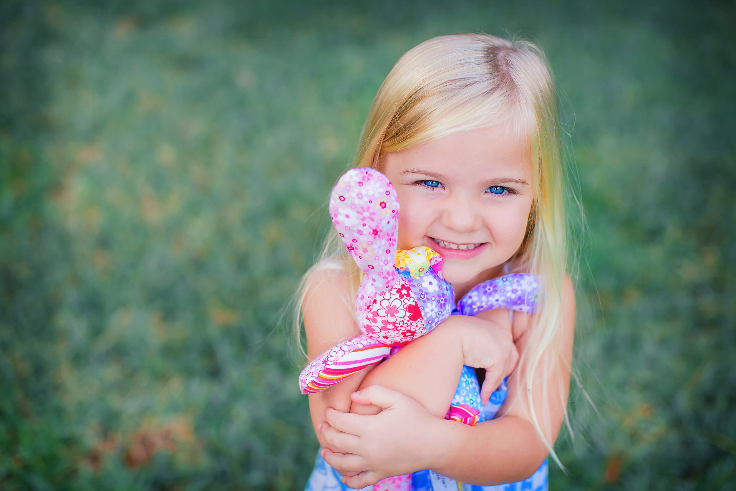  Young girl hugging favorite colorful stuffed bunny by family photographer spryART photography 