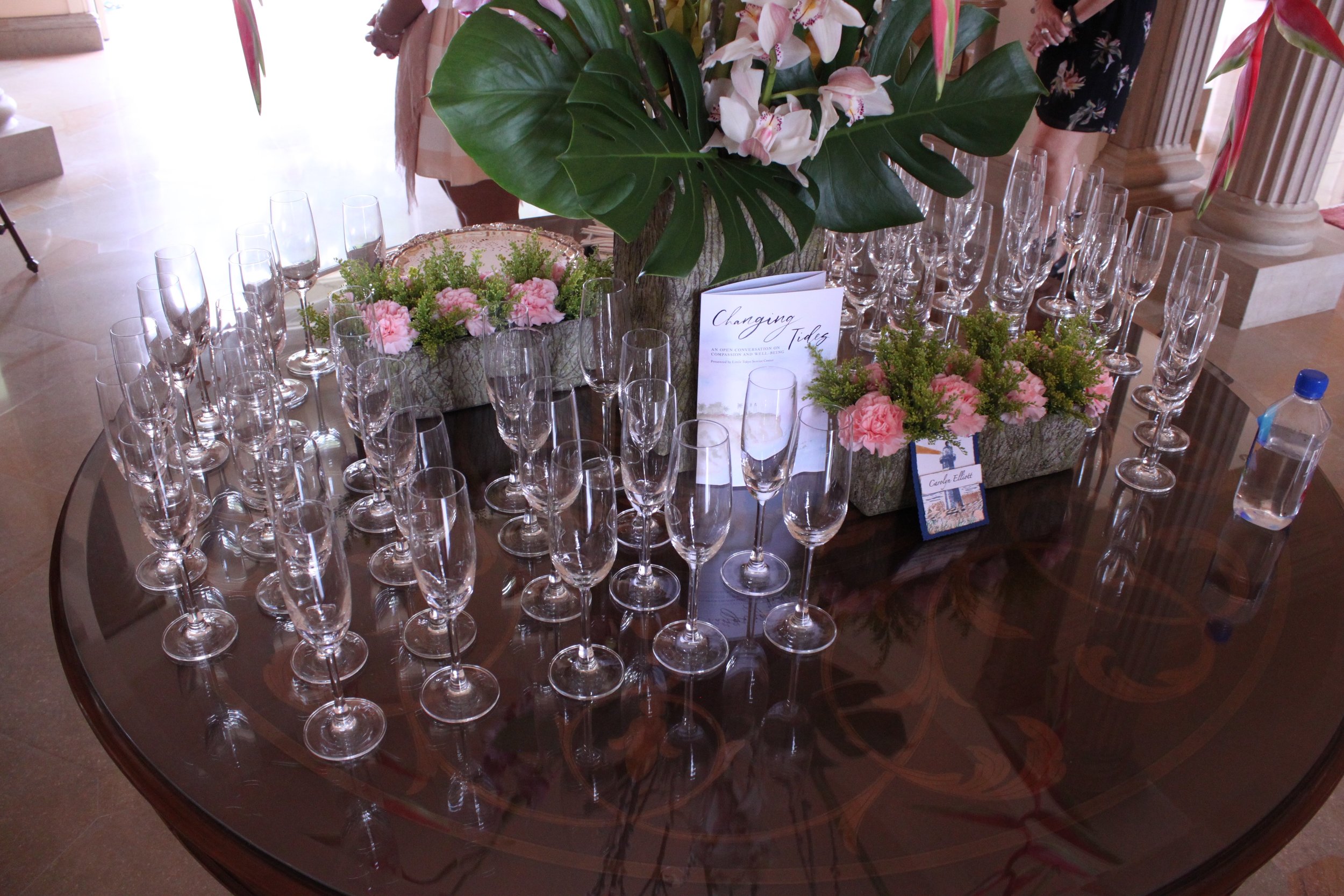 A group of champagne flutes rest on a table.