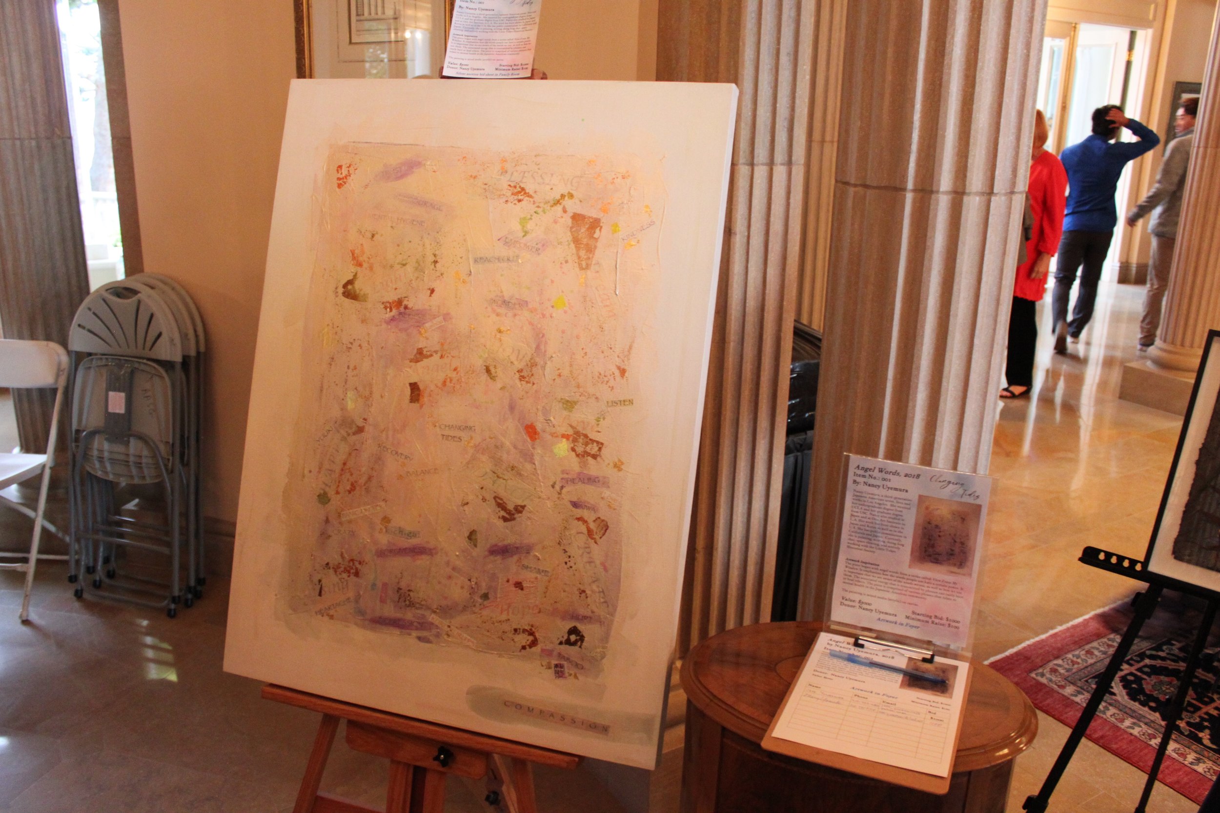 A large painting is displayed on an easel.