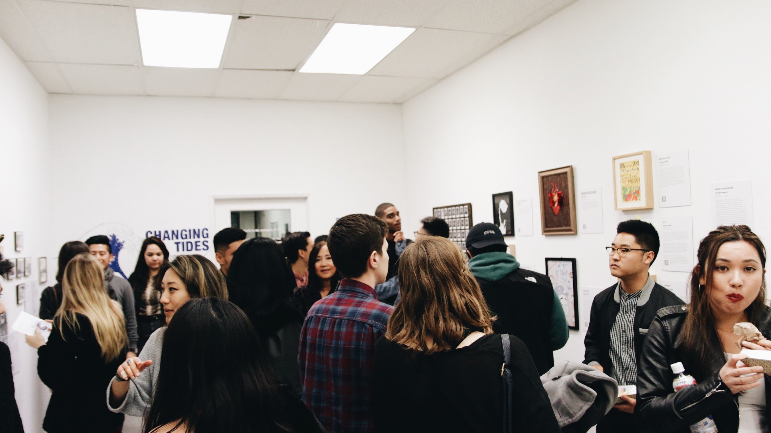 People mingle in a gallery space.