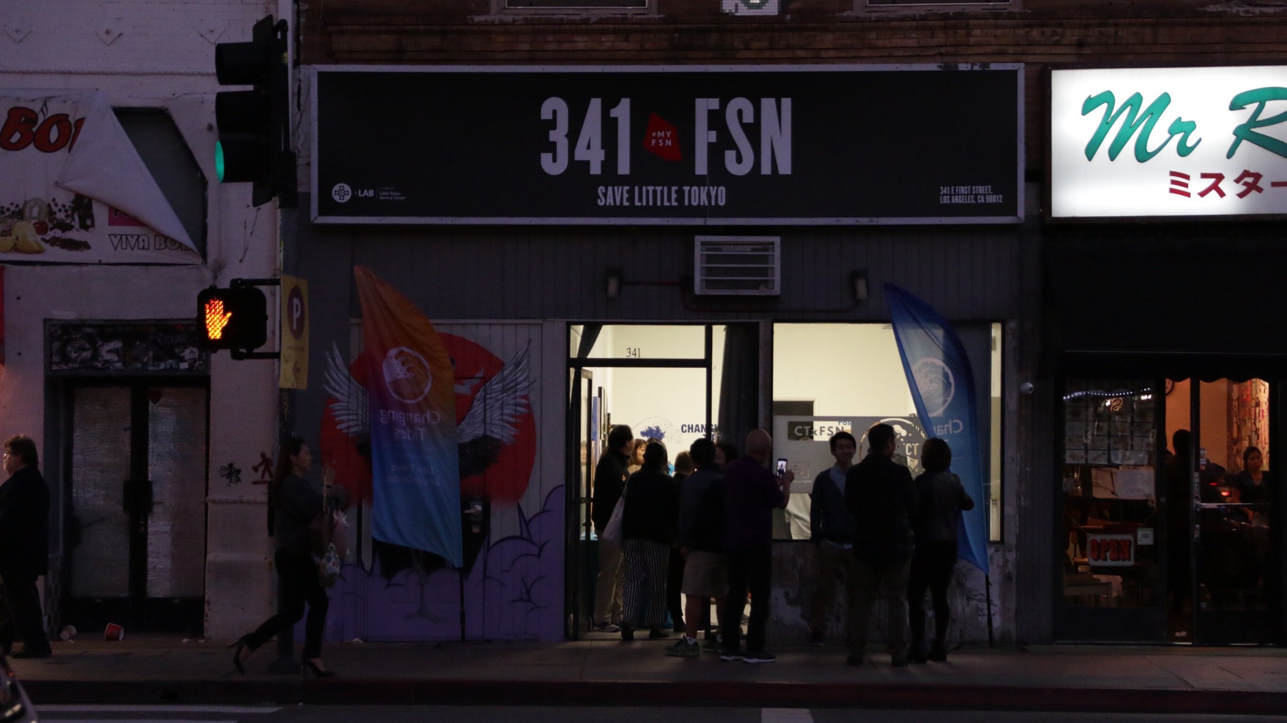 People gather at night outside the 341 FSN, Save Little Tokyo building. 