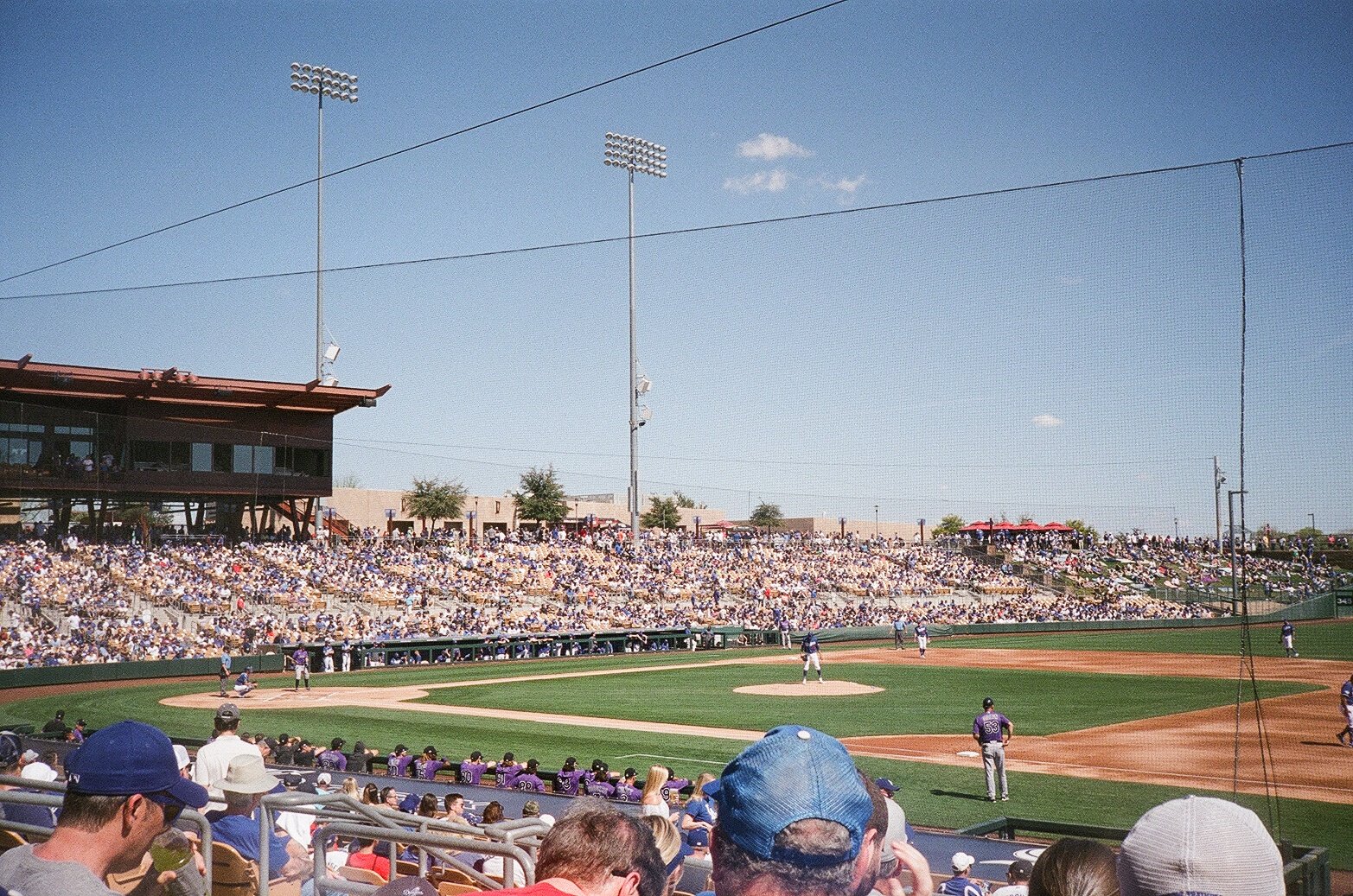A baseball field is seen with fans in the stands and players on the field during a game. 