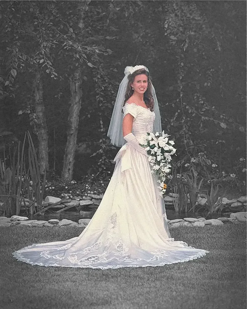 A bride in a white dress and veil and holding white flowers