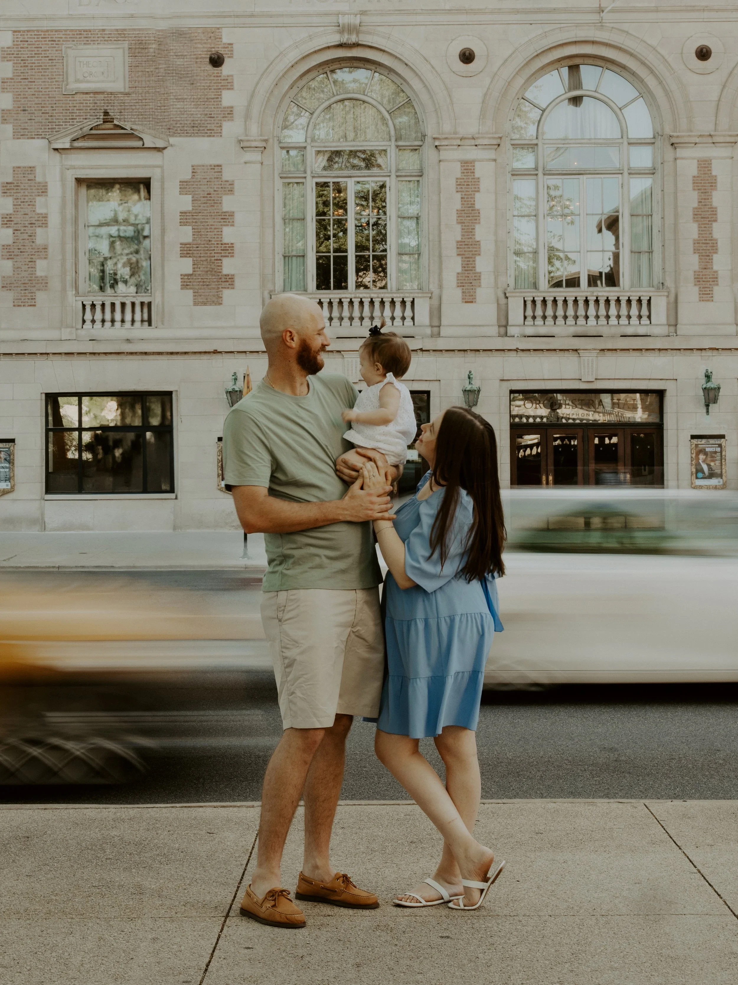 Family with baby standing in front of Chicago building during lifestyle photography session