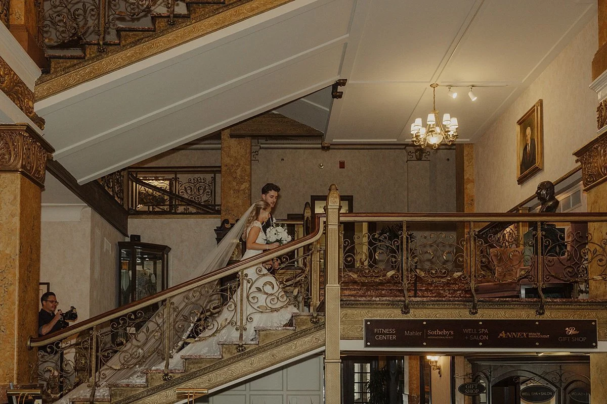 Newlyweds walk upstairs in a bridal portrait taken at their pfister wedding
