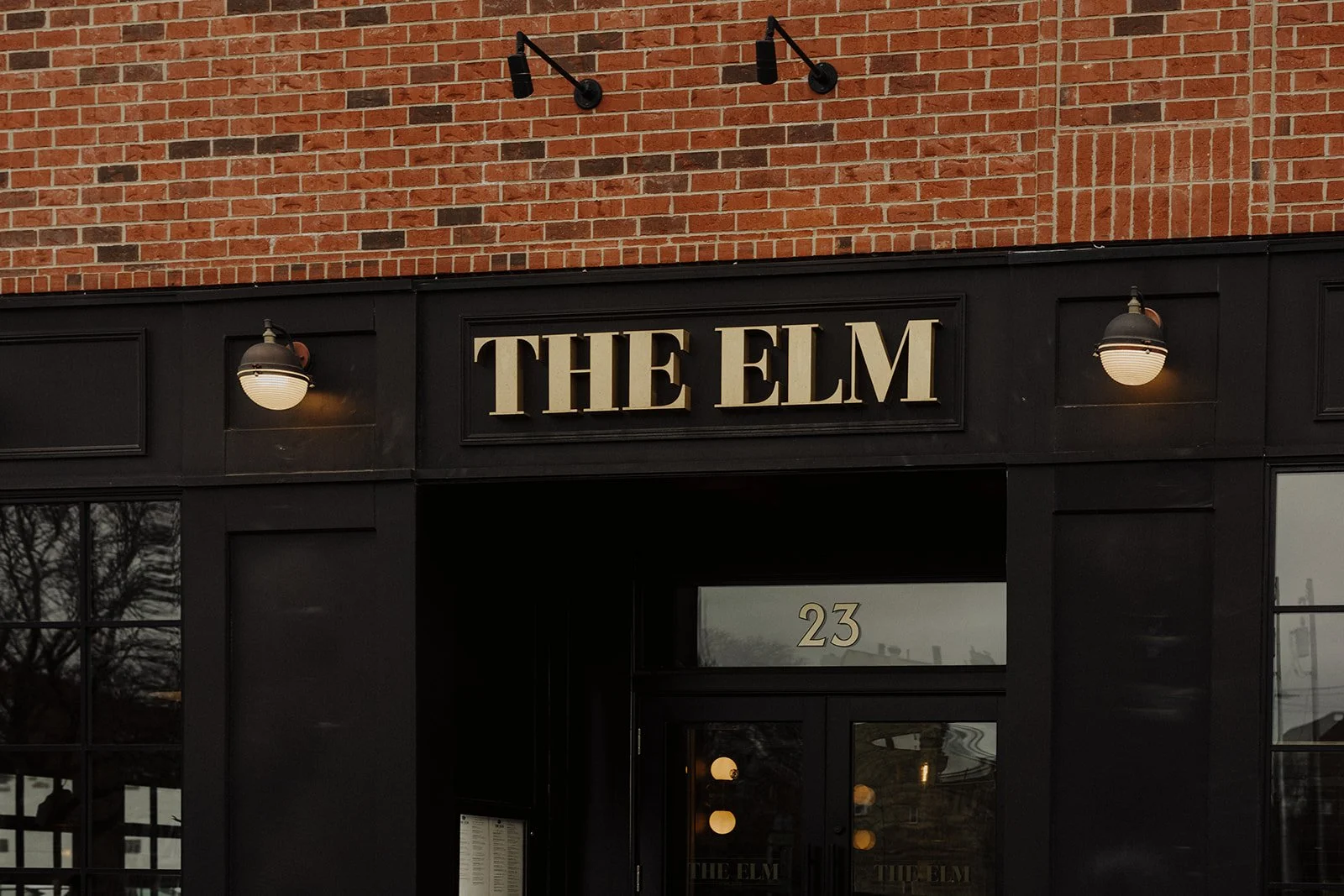 The Elm Lagrange Illinois is photographed from the front sidewalk showcasing the brick exterior and restaurant signage
