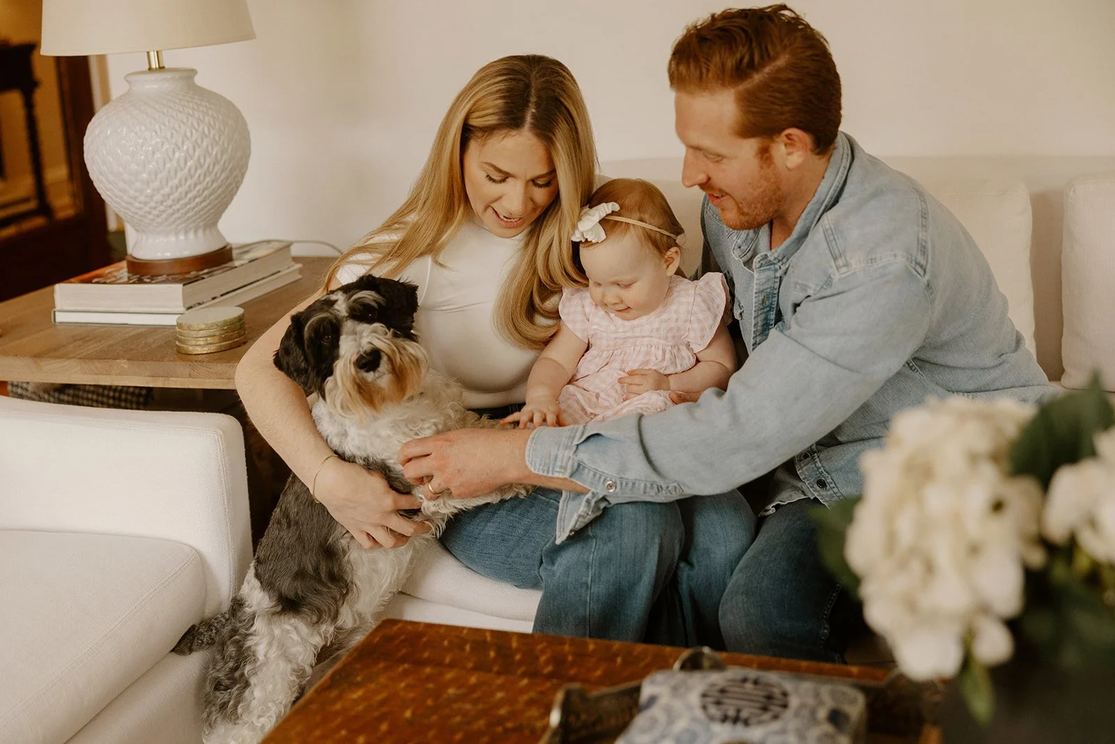 A couple with their baby daughter & pet dog gather in their condo living room for in-home family photos Chicago.