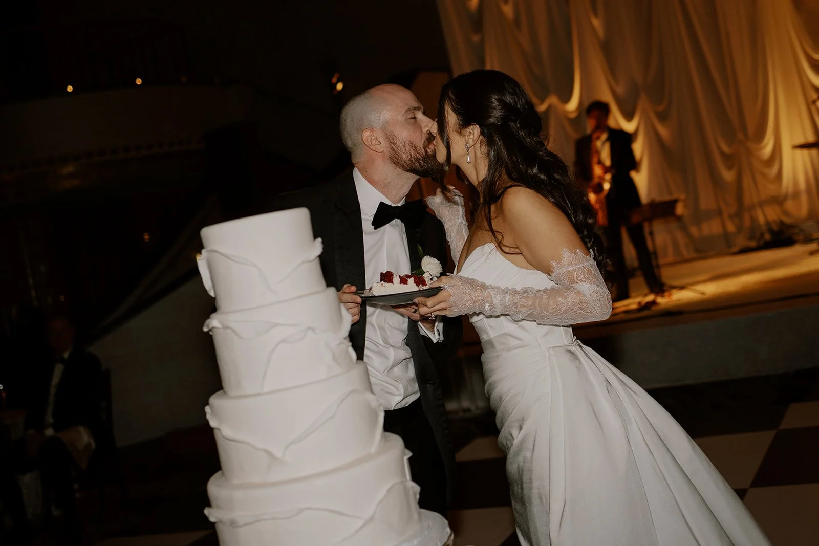 Newlyweds share a kiss and a slice of wedding cake at their Intercontinental Chicago wedding reception.