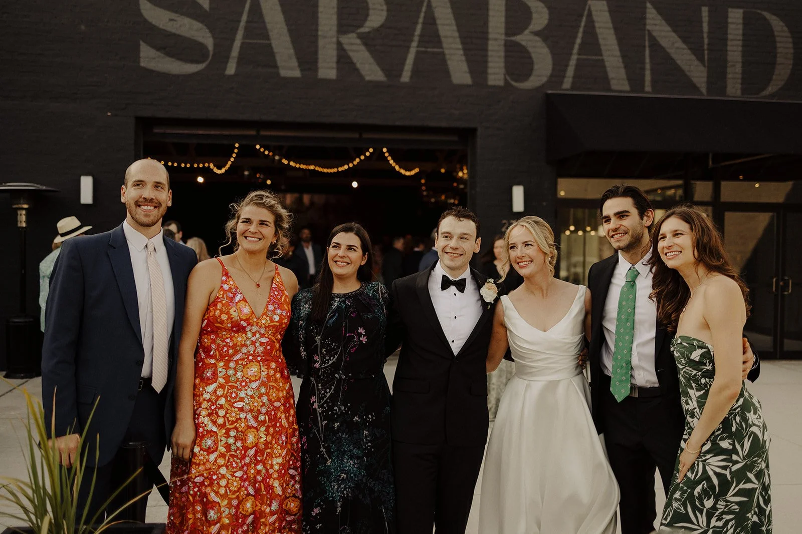 Newlyweds pose for a photo with guests outside the Sarabande, a chicago wedding venue