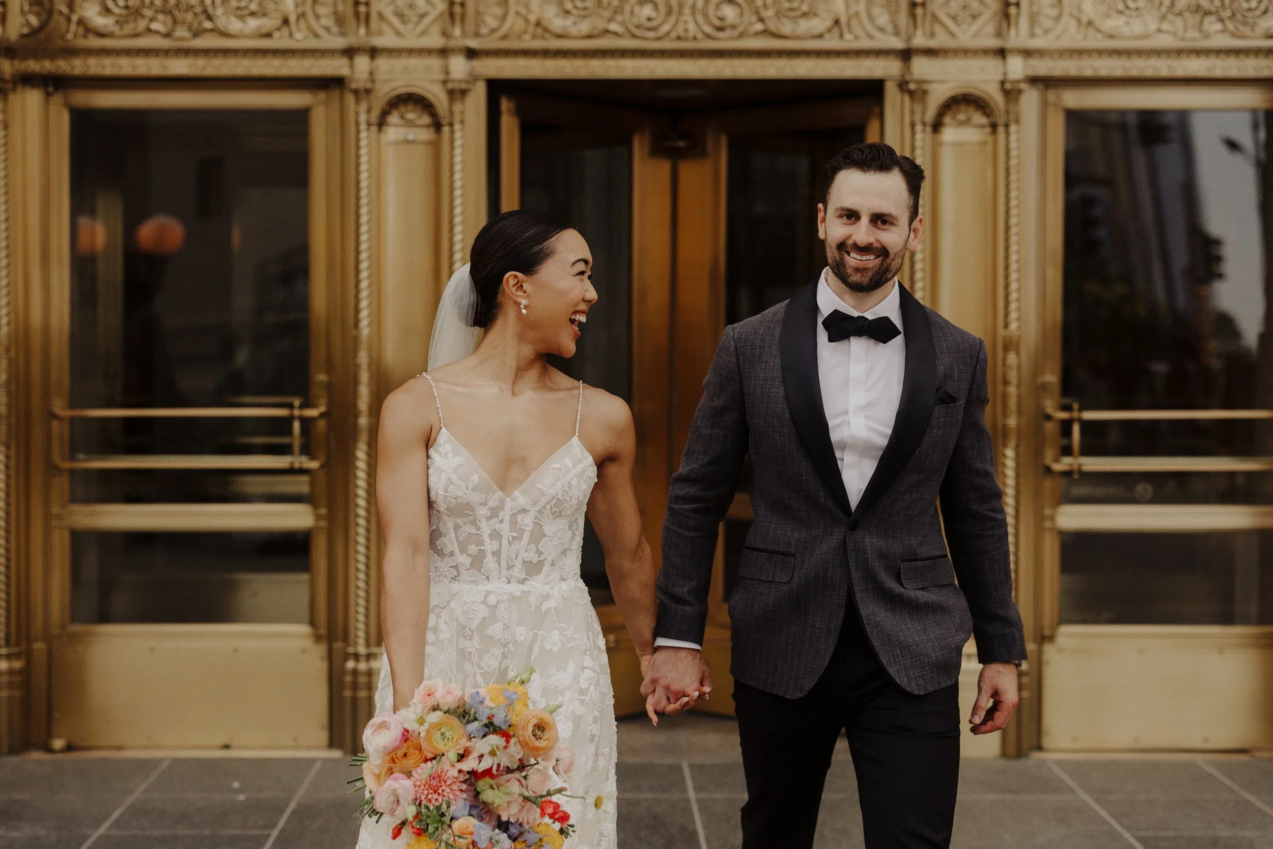 Bride and groom walking hand in hand outside building captured for Chicago wedding photography