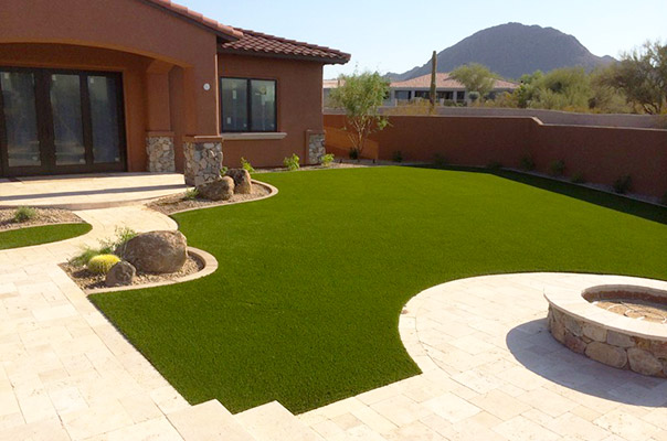  Residential artificial grass installation with travertine paver fire pit and border installation. 