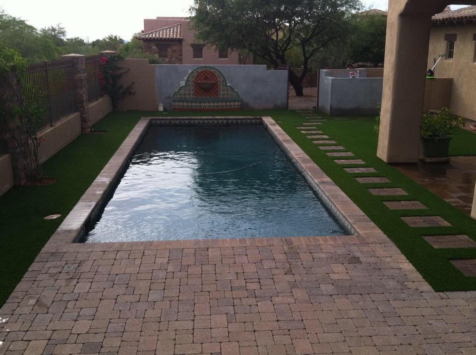  Artificial grass installation with paver patio and paver stepping blocks inset  