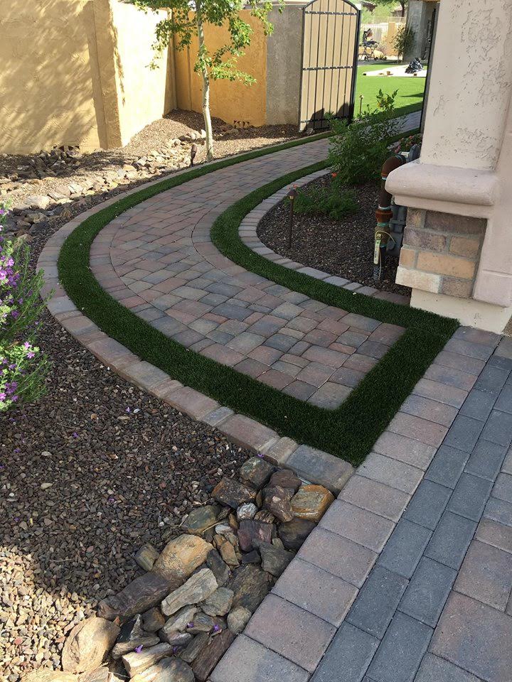  Artificial grass installed adjacent to paver patio walkway adding visual interest and texture to installation. 