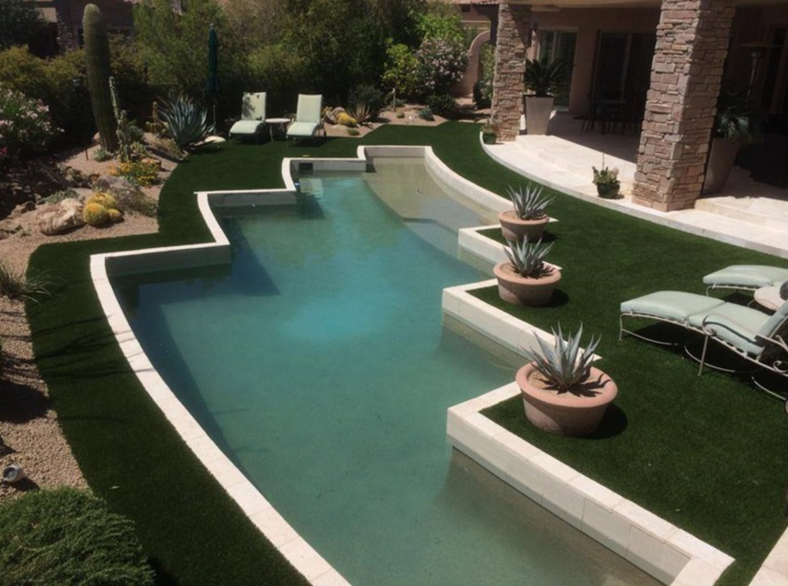  Artificial turf installed adjacent to swimming pool.  