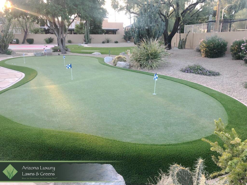  Artificial grass installation with putting green surrounded by gravel and paver walkway 