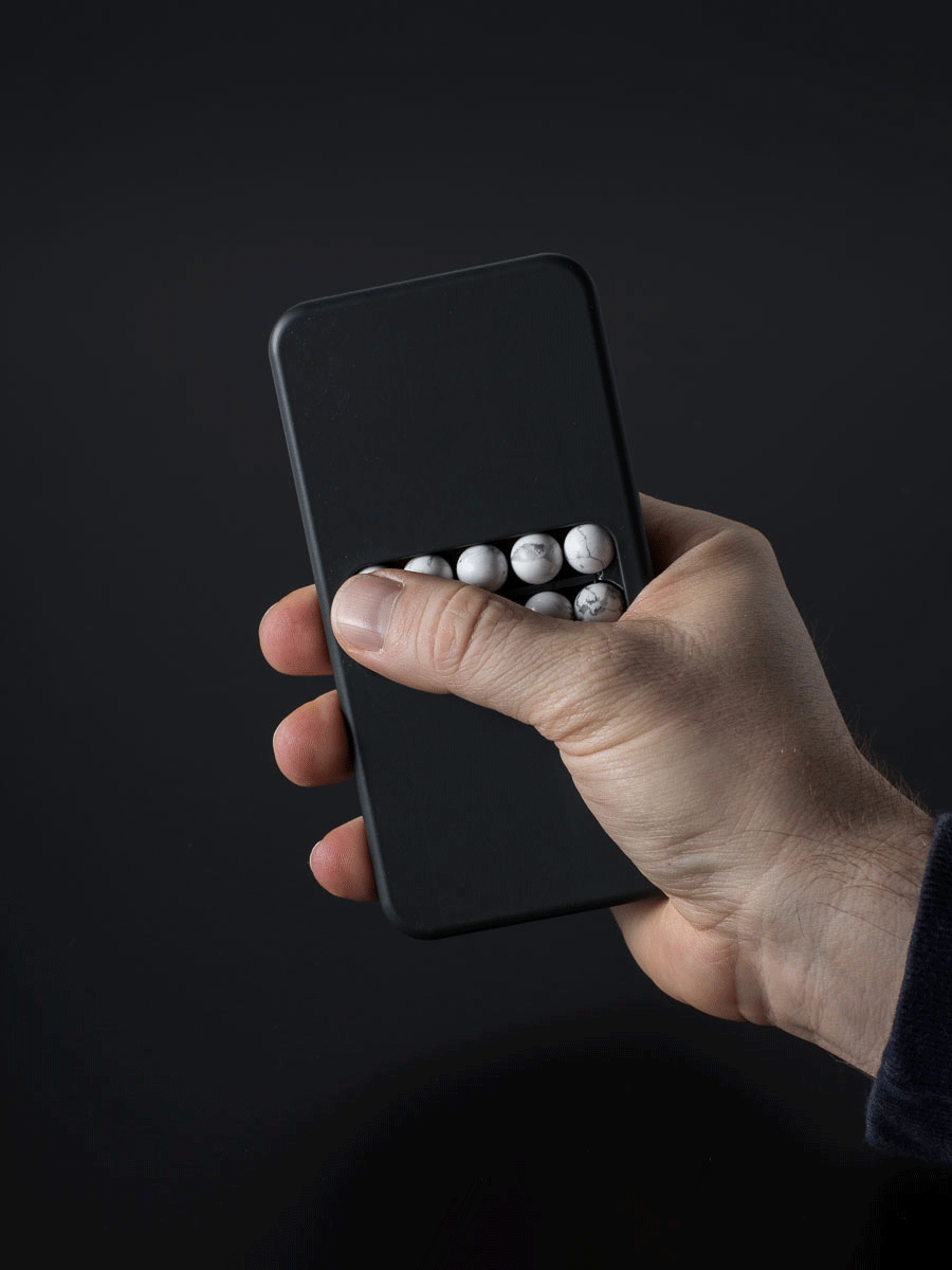 A GIF of a person holding a substitute phone and sliding their thumb back and forth over the beads.
