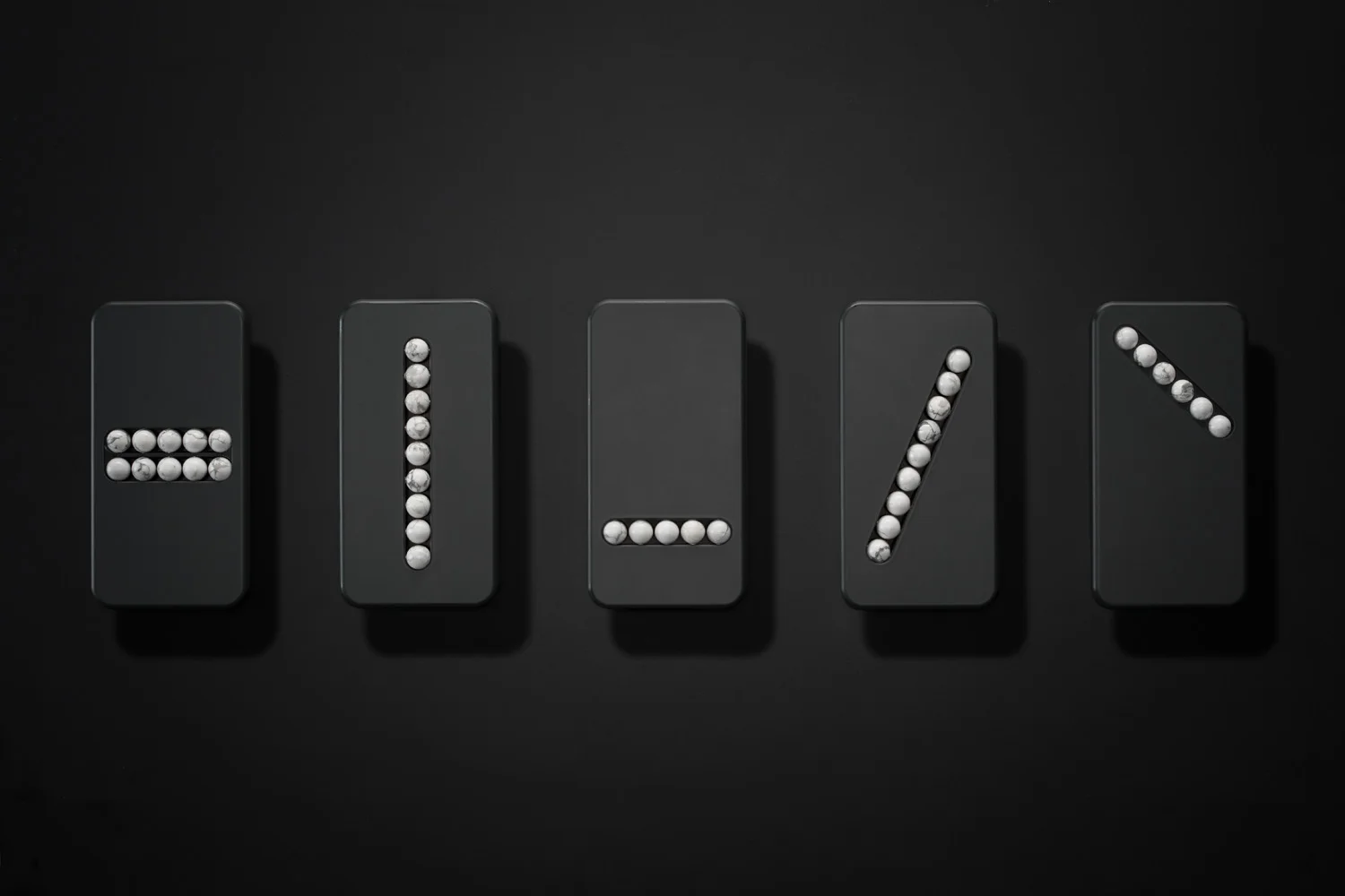 A photo of the various substitute phones laying on a table. Each has beads in it but they vary in the direction they are laid.