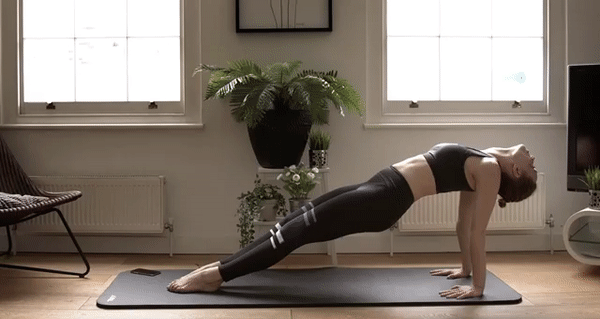 A GIF of a woman doing yoga in NADI X pants. It says “Gentle Vibrations” over her.