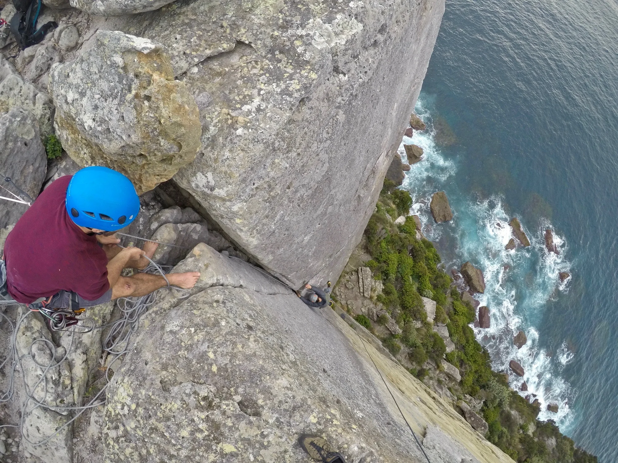 Qualified rock climbing guide managing rope safety and providing instruction on a cliff in New South Wales