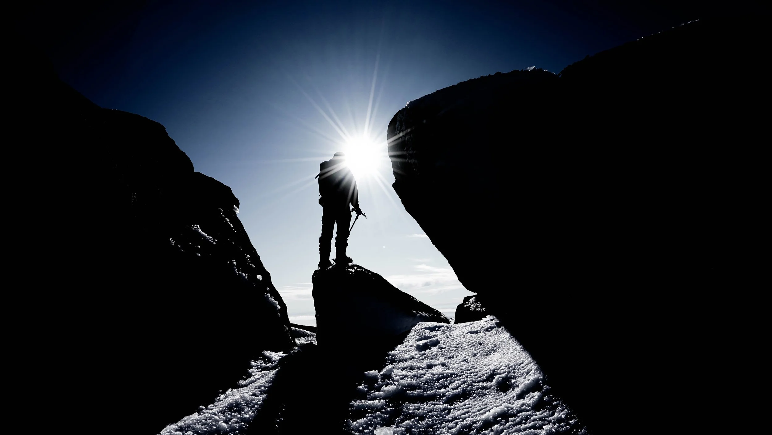A guided mountain climber in winter summit on a sunny day with Big Nature Adventures.
