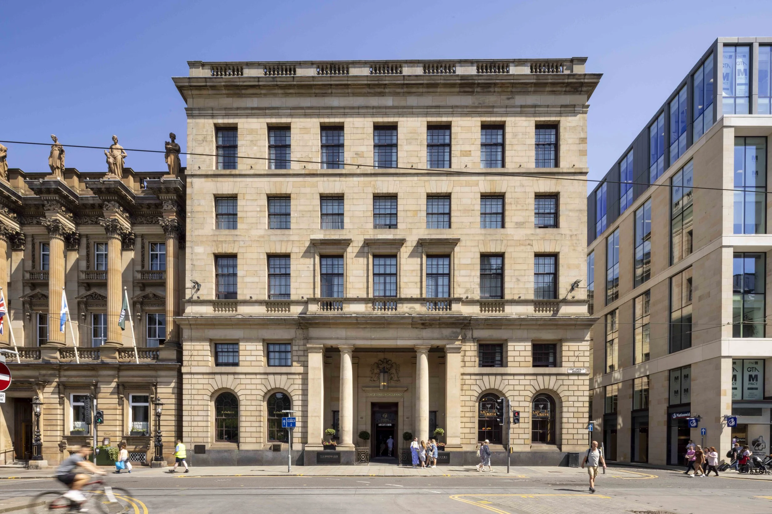 Historic city street with neoclassical building and pedestrians