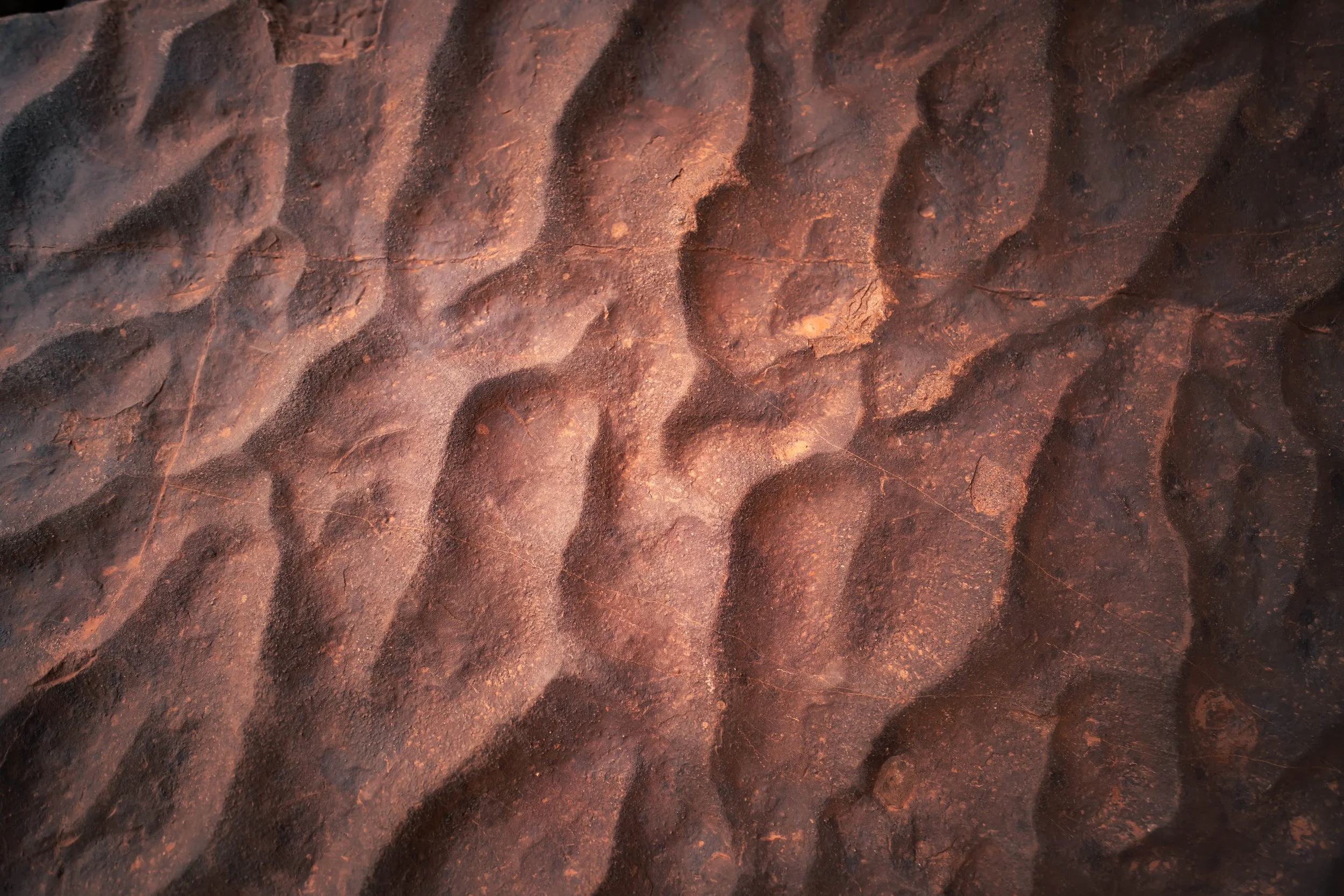close-up image of red rock with peaks and valleys in the surface