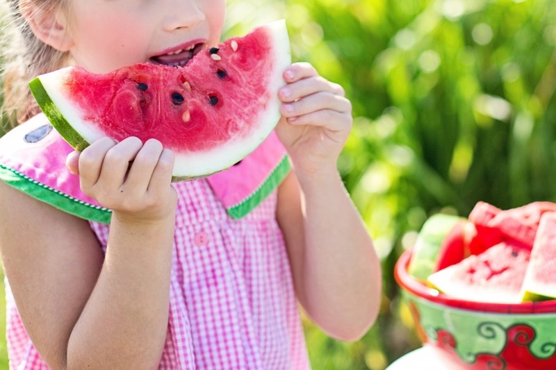 girl-eating-watermelon-in-garden-on-summer-day.jpg