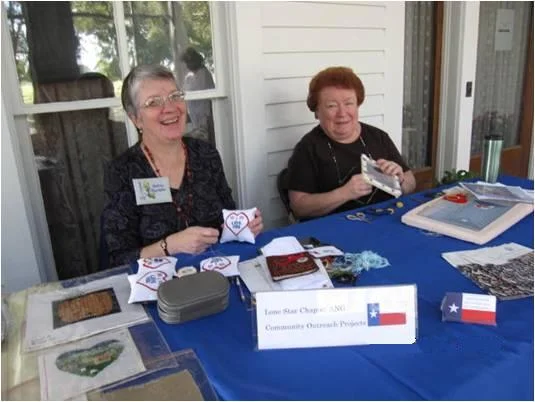 Andrea Standefer (L) and Linda Edney (R) stitch on the porch of the main house.