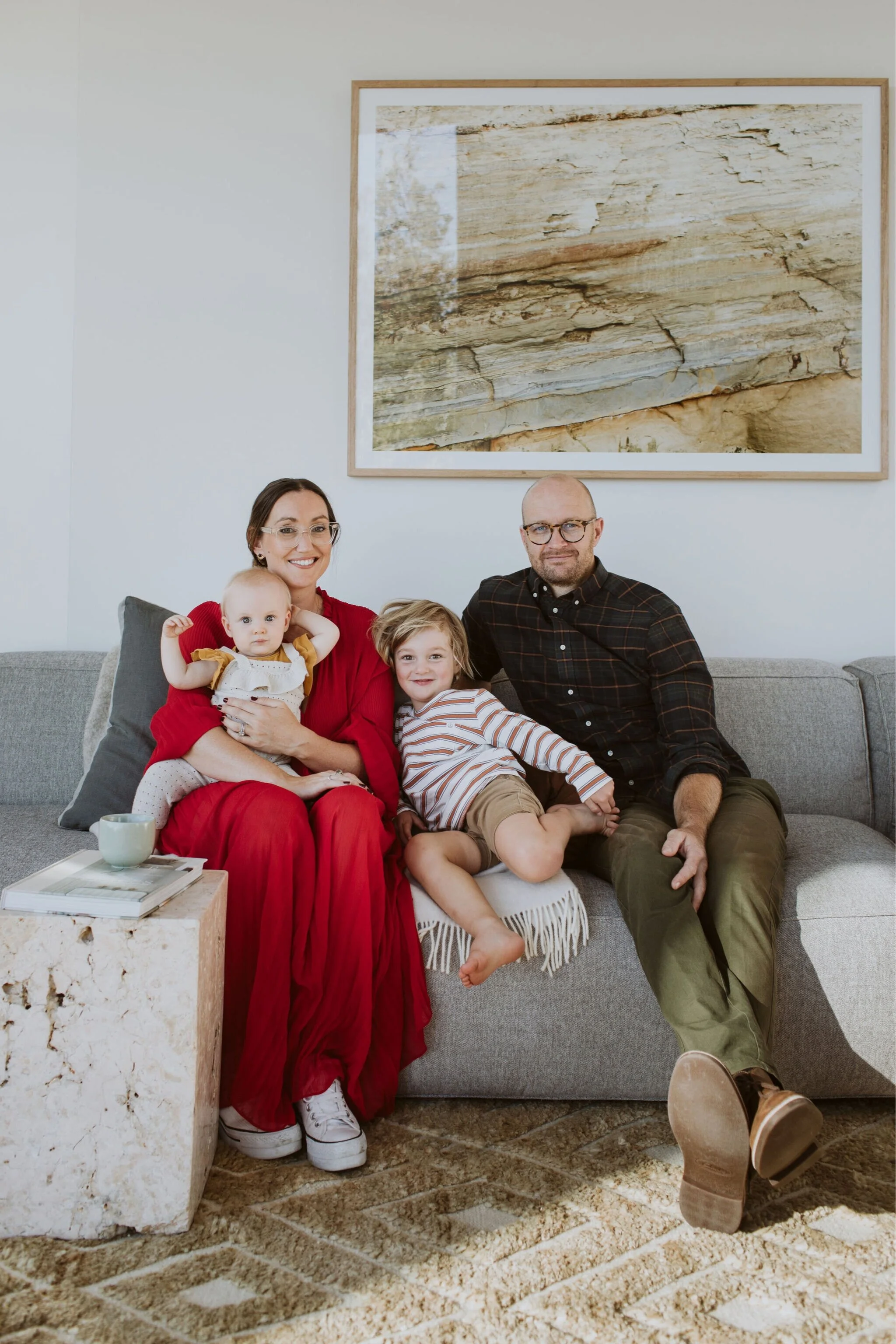 Here we are. The full fam bam. Alex, Corban and our two kids Goldie and Austen. Sitting in our Living Room with a photo Alex took of the Island Bay Beach cliff face, which happens to be the same photo she used to inspire the colour and material use in the home.