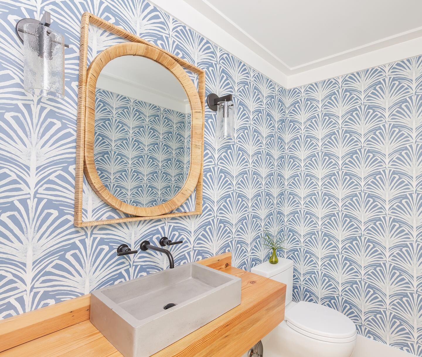 Absolutely adore the way this wallpaper turned out in the powder room of our Spartina project 💙😍💙 the blue walls mixed with warm wood and rattan are the prefect combo for this coastal home. Photography credit goes to @calliecocreative #indigoalley