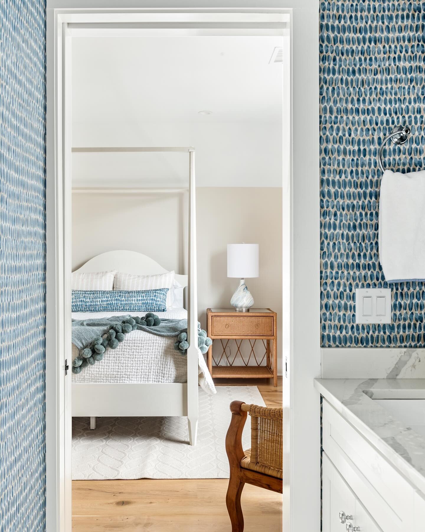 We love creating spaces that surprise and delight! The fun bathroom drama gives way to a calm bedroom retreat. The bold wallpaper is balanced by the serene neutrals in the connecting space. ✨ want your house to tell a story like this? Give us a call!