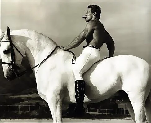 Arnold Schwarzenegger on a white horse with a cigar in his mouth.