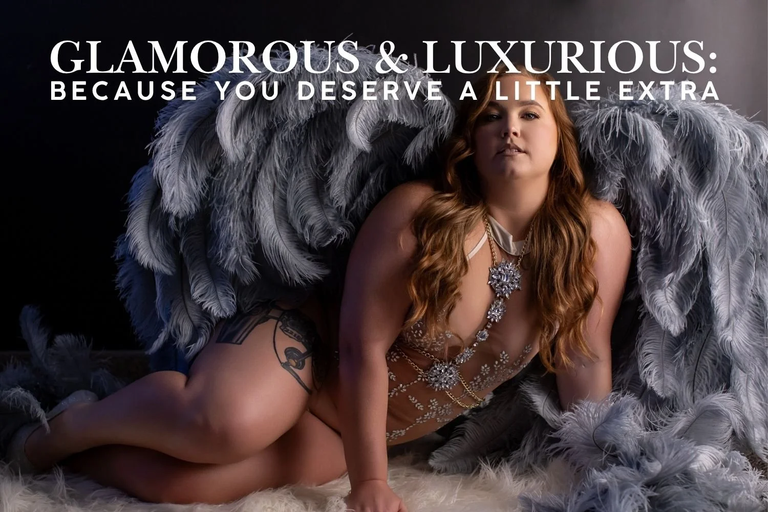 Glamorous boudoir portrait featuring a woman in jeweled lingerie surrounded by dramatic gray feathered wings.
