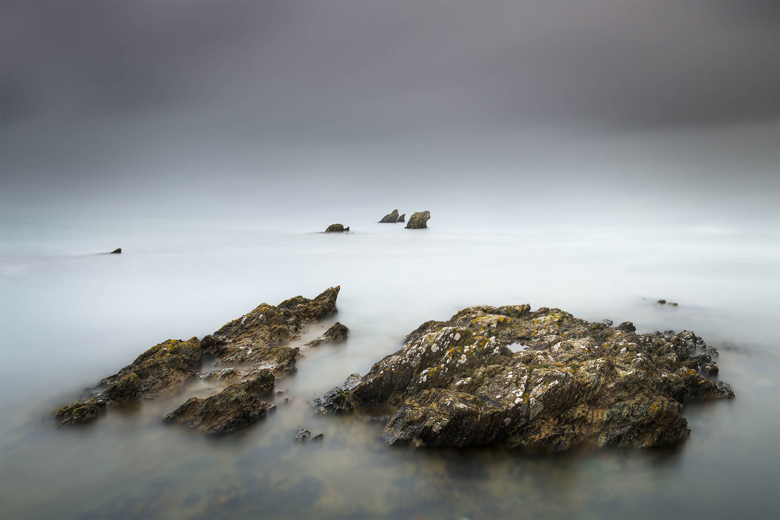 Bull Bay Long Exposure Seascape – Anglesey Fine Art

Captured on the rugged coastline of Bull Bay in Anglesey, this minimalist long-exposure seascape blends soft, mist-like water with the texture of dark coastal rocks. The muted tones create a calmin
