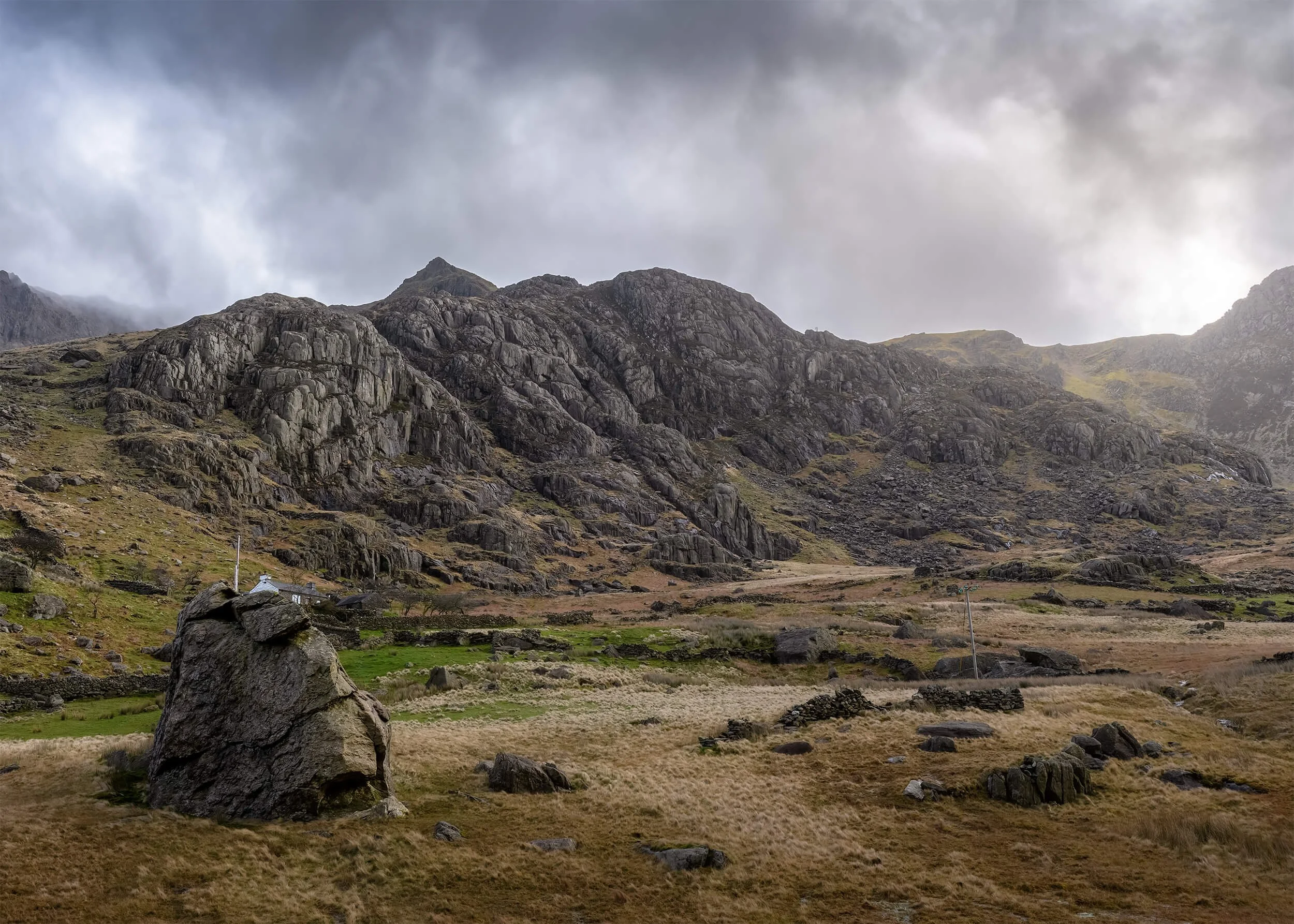 Quietude captures a moment of stillness in the mountains of Eryri, North Wales. Heavy skies drift above the rugged rock formations while soft light moves across the landscape below. Scenes like this reveal the quiet power of the Welsh mountains, wher