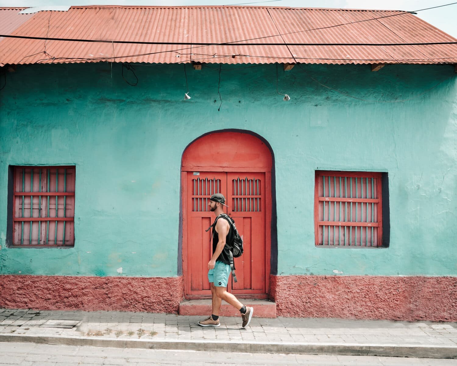 wes walking in front of blue hosue with red door.jpeg