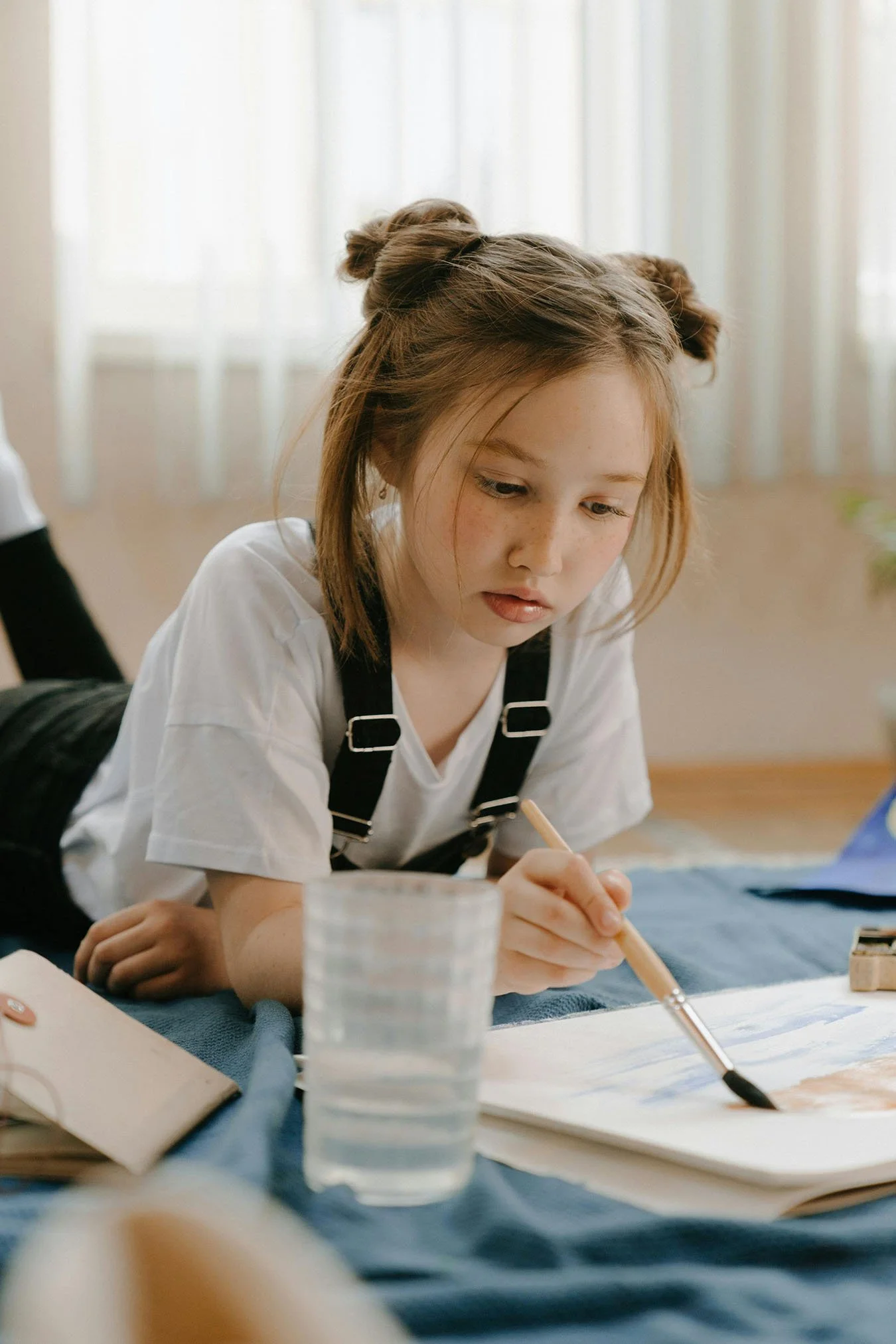 Child focused on painting activity during therapy session using creative approaches for anxiety