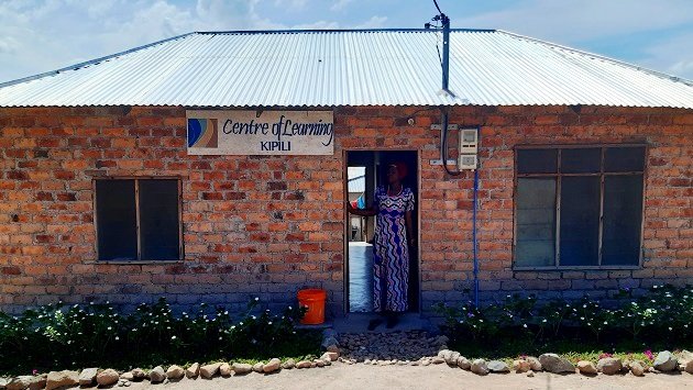 Lake Shore Lodge Tz - Lake Tanganyika - Giving Back - Gloria at the entrance to the Centre of Learning.jpg