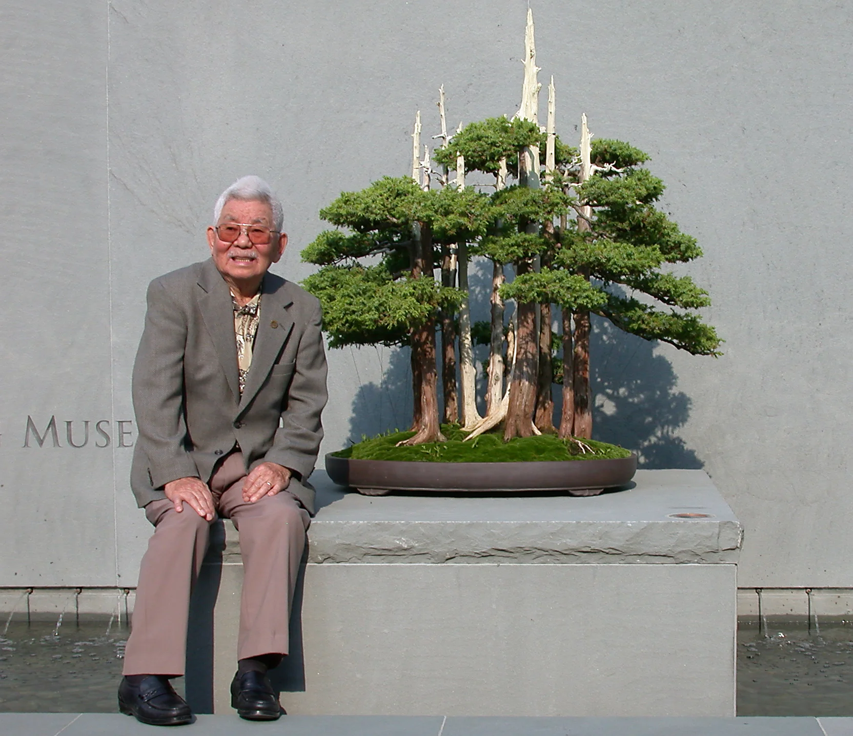 John Naka pictured with "Goshin" at the entrance to the Upper Courtyard (2003)