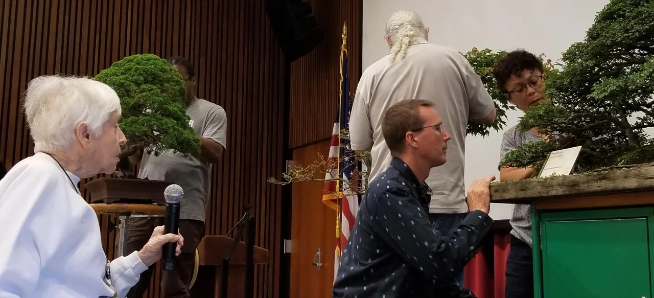 NBF board member and Vice President, Marybel Balendonck, holds microphone as Michael Hagedorn works on the tree that she donated to the Museum. (Photo courtesy of Michael James)